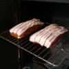 Pork_Loin_covered_with_bacon_going_into_smoker
